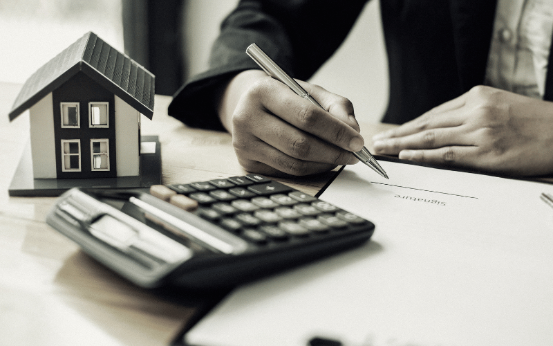 a person signing a document for divorce with calculator on the side
